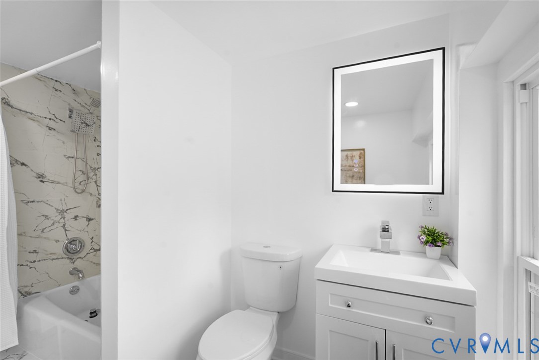 White vanity with under-sink storage, integrated sink, and chrome faucet