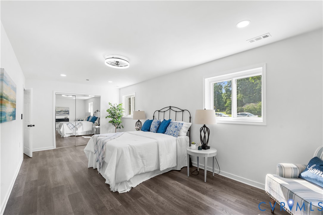 Wood-finish flooring throughout, white walls, recessed lighting, and a ceiling fan with integrated lighting