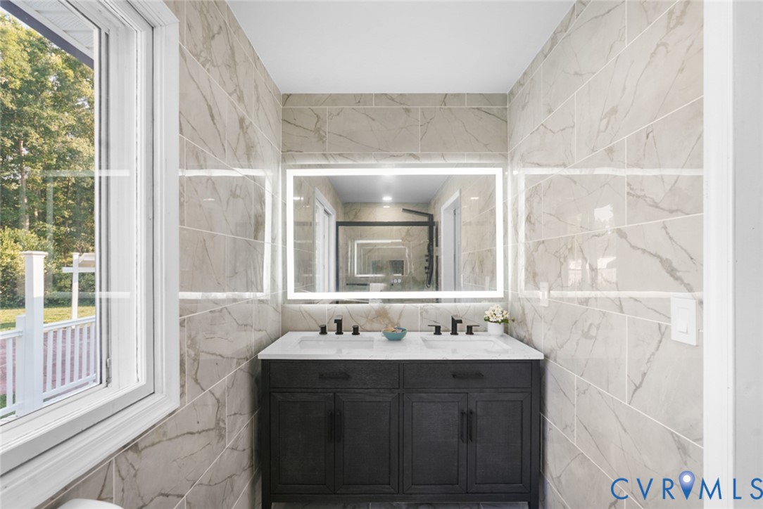 Double vanity with integrated sinks, dark wood-finish cabinetry, and matte black fixtures