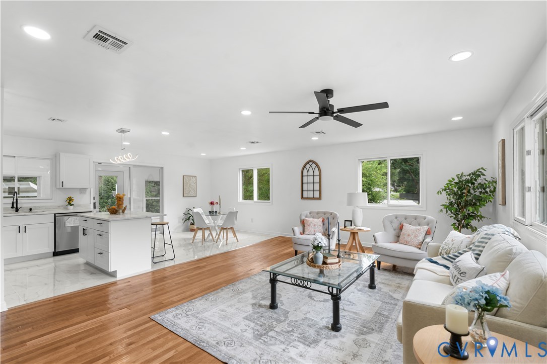Open concept living area with recessed lighting, wood-finish flooring, and a modern ceiling fan