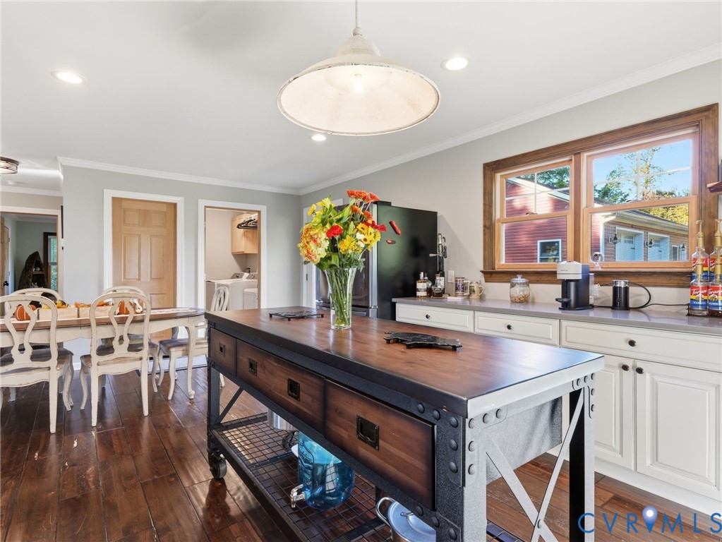 Kitchen featuring a mobile industrial-style island with a wood countertop, white shaker-style cabinetry, recessed lighting, and a pendant fixture over the workspace