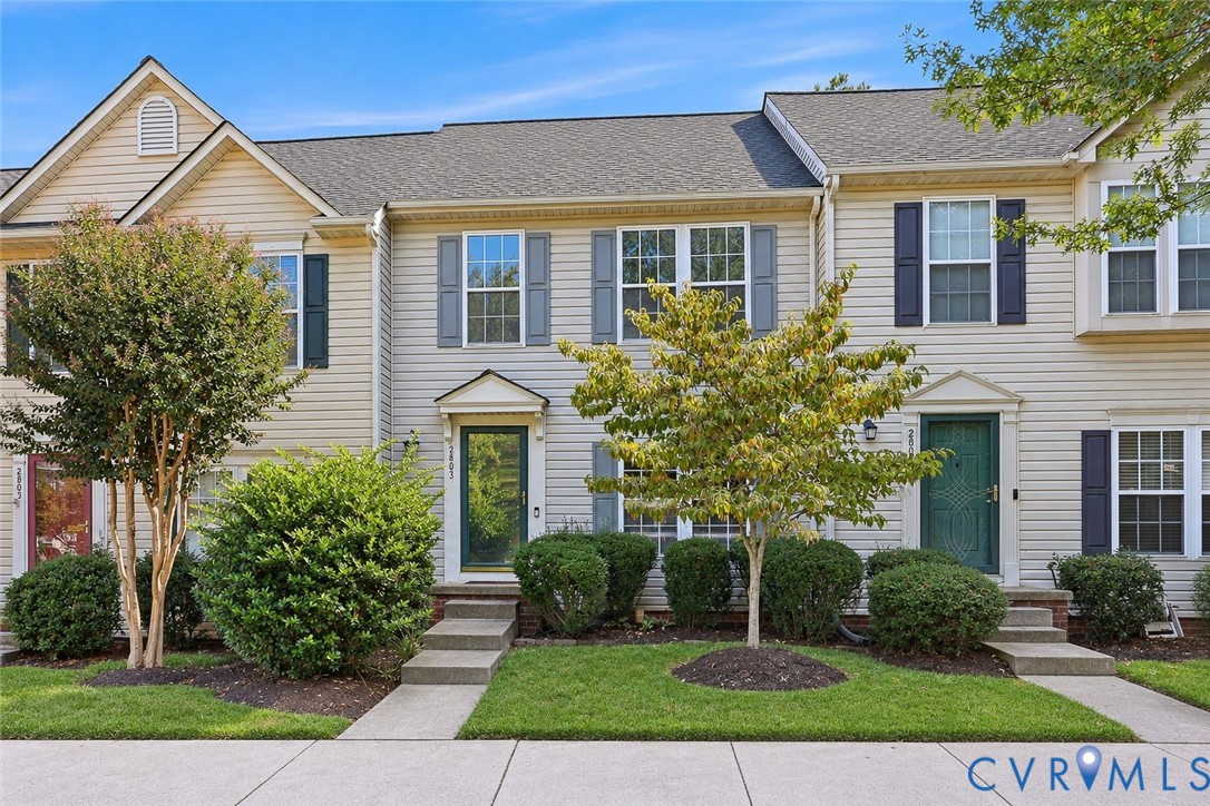 Multi-level exterior featuring horizontal siding, asphalt shingle roofing, decorative window shutters, and landscaped front lawn with concrete walkways Multi-level exterior featuring horizontal siding, asphalt shingle roofing, decorative window shutters, and landscaped front lawn with concrete walkways