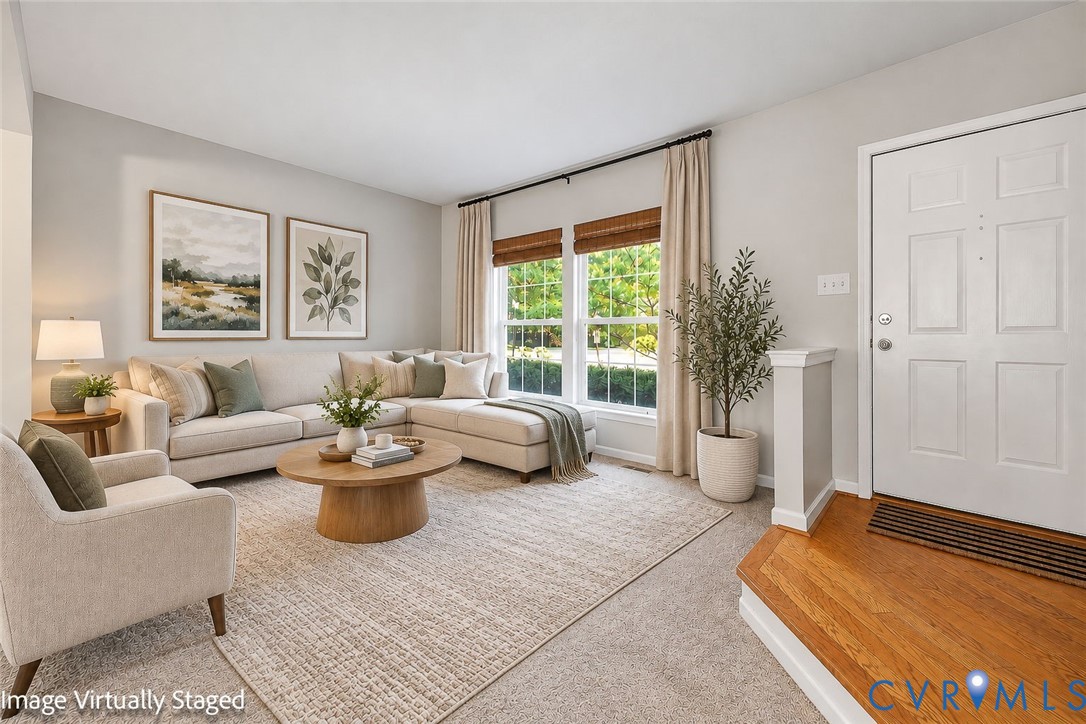 Living area featuring neutral wall paint, expansive windows, and a raised entry platform with hardwood flooring Living area featuring neutral wall paint, expansive windows, and a raised entry platform with hardwood flooring