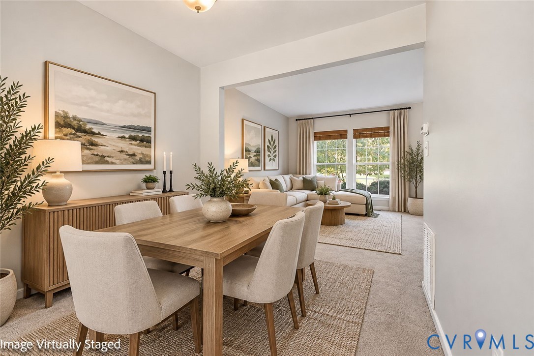 Neutral wall tones, carpeted flooring, and multi-pane windows with window treatments