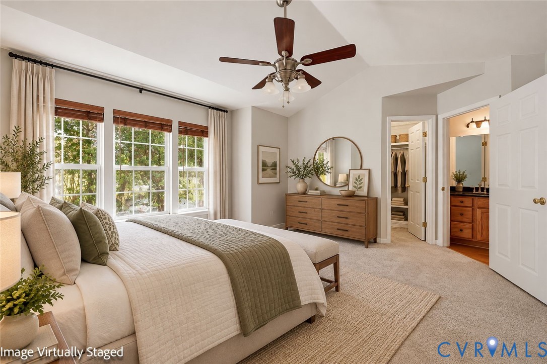 Vaulted ceilings featuring a multi-blade ceiling fan, expansive grid windows, wall-to-wall carpeting, and a reach-in closet with built-in shelving