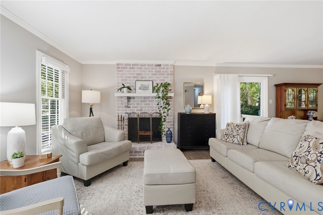 Bright gathering space featuring a brick fireplace for cozy evenings