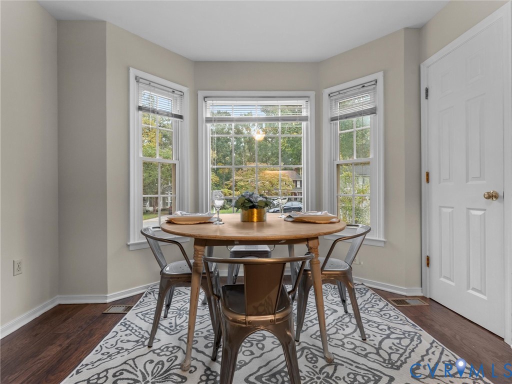 Bay window featuring three multi-pane windows and wood-finish flooring Bay window featuring three multi-pane windows and wood-finish flooring