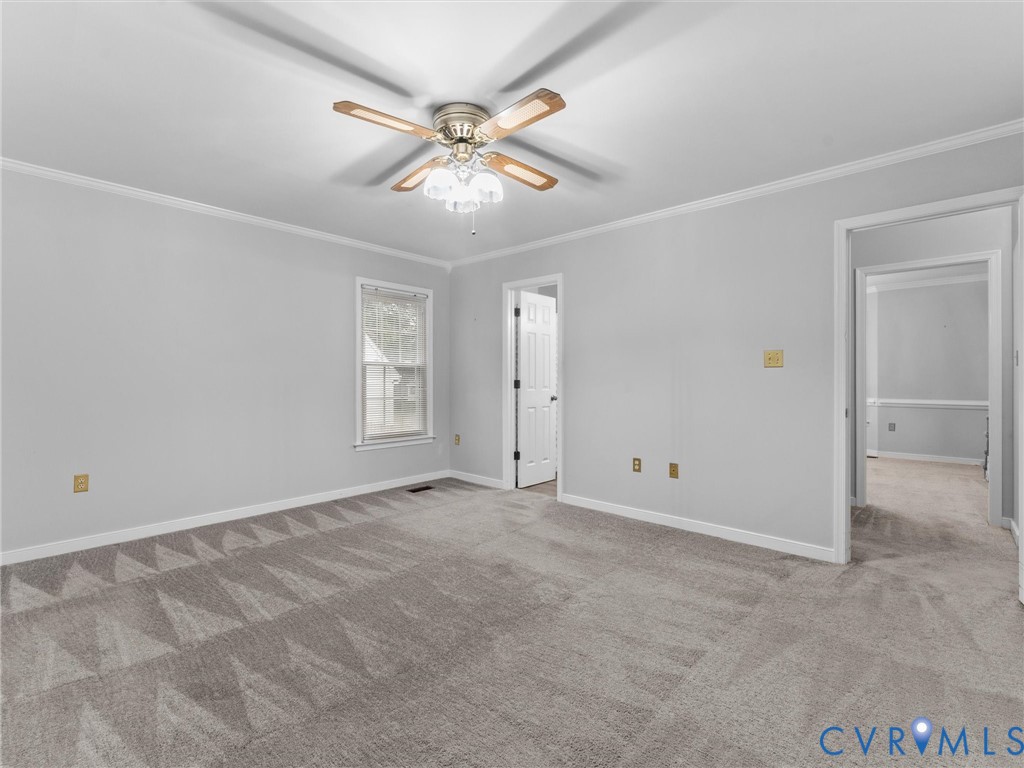 Neutral wall palette, carpeted flooring, ceiling-mounted paddle fan with multi-light fixture, and multi-pane window
