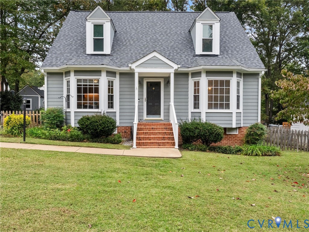 Cape Cod-style residence featuring horizontal siding, twin dormer windows, dual bay windows, and a brick-stair entry with a covered porch Cape Cod-style residence featuring horizontal siding, twin dormer windows, dual bay windows, and a brick-stair entry with a covered porch