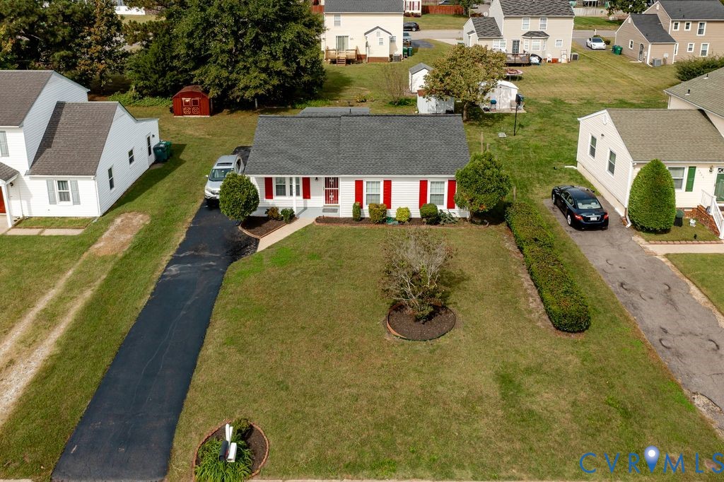Single-story residence featuring a white exterior with contrasting red shutters, asphalt shingle roof, expansive front lawn, and a private asphalt driveway Single-story residence featuring a white exterior with contrasting red shutters, asphalt shingle roof, expansive front lawn, and a private asphalt driveway