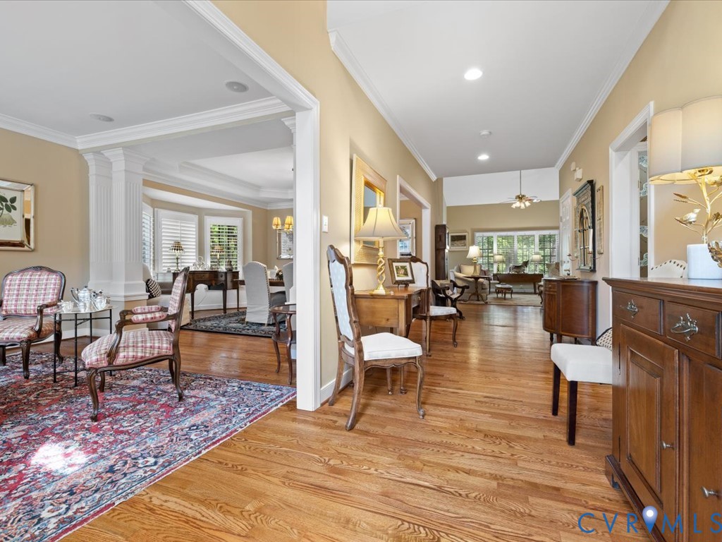 Hardwood flooring throughout, recessed ceiling lighting, crown molding, and architectural columns