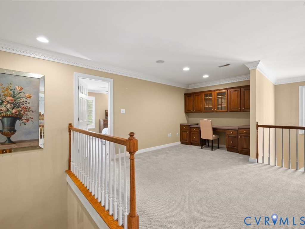 Open loft space featuring recessed lighting, built-in cabinetry, crown molding, and carpet flooring