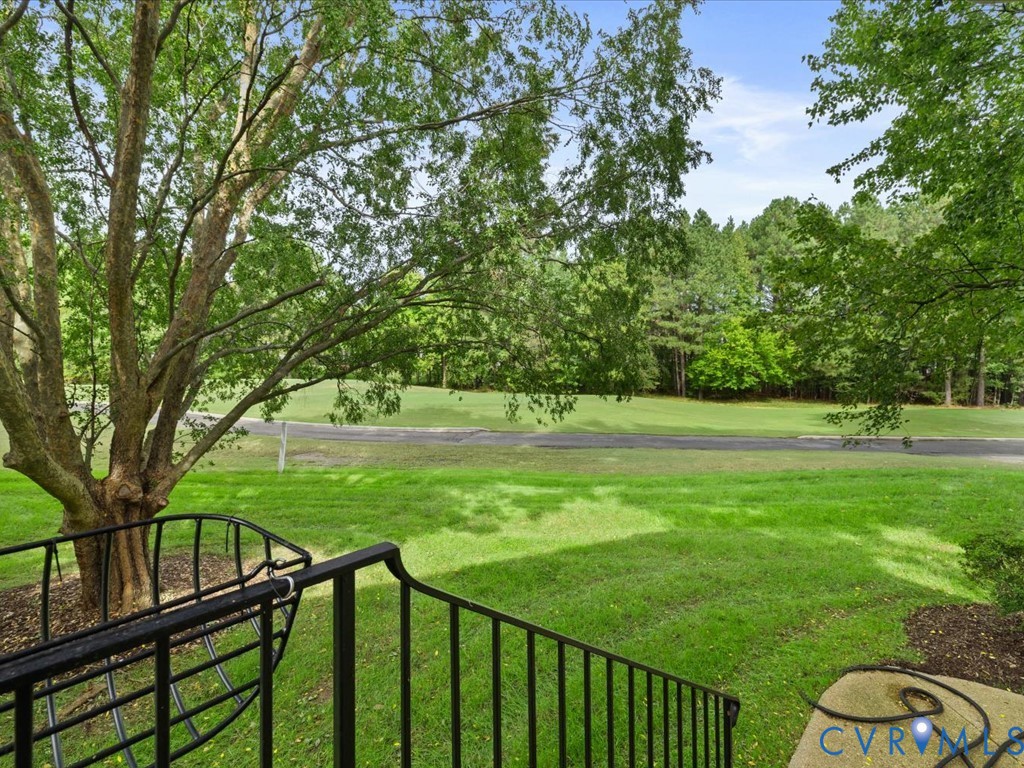 Expansive green lawn with mature trees and paved road
