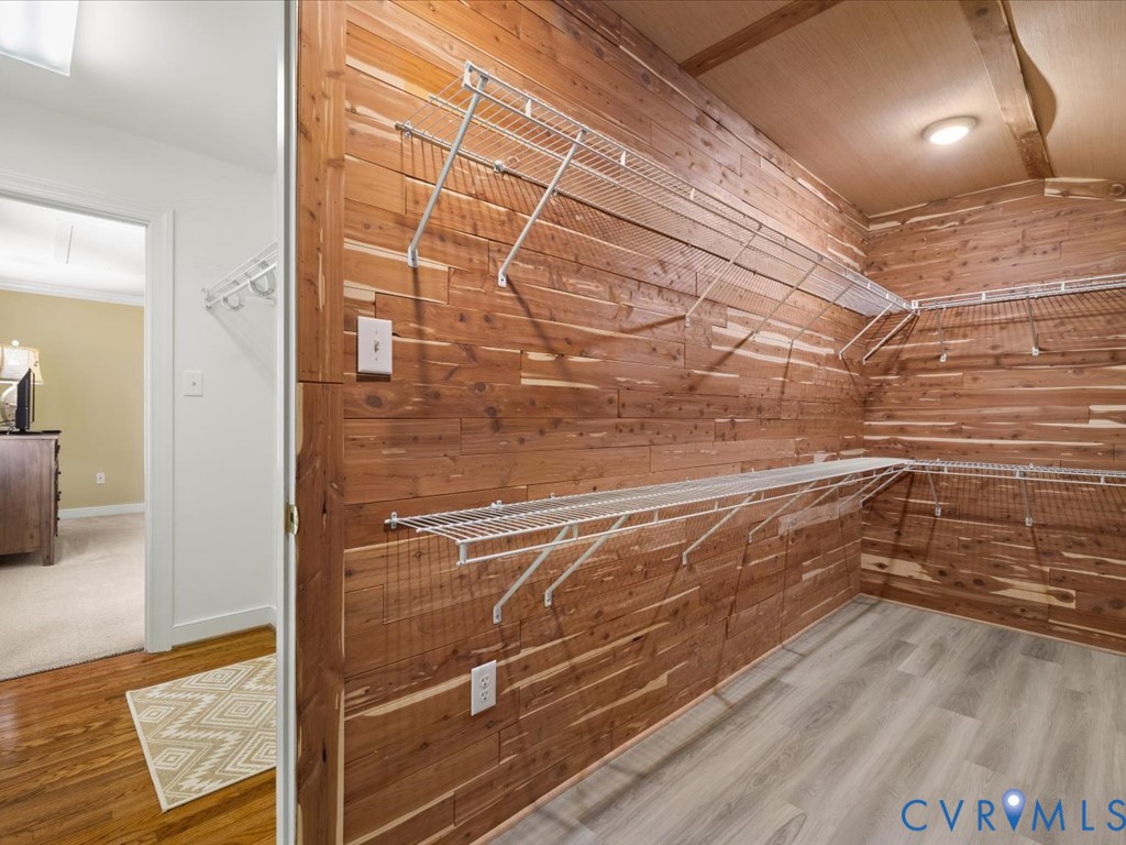 Wood-paneled closet with wire shelving and recessed lighting