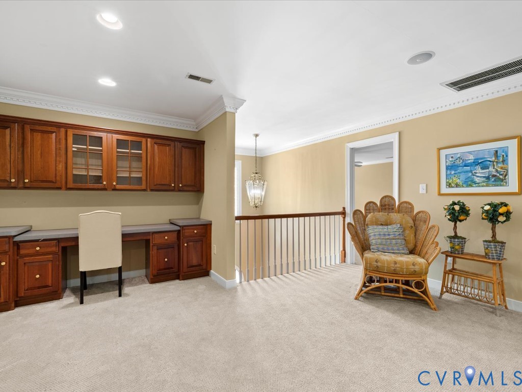 Built-in cabinetry with glass-front uppers, integrated desk space, and crown molding accents