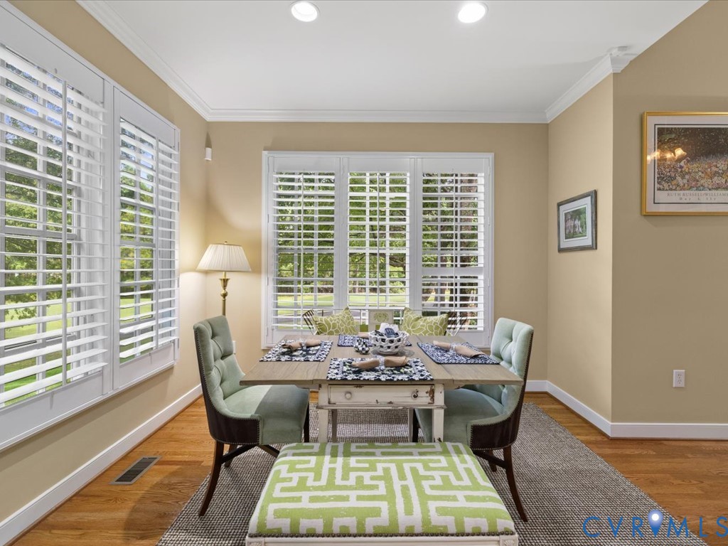 Hardwood flooring, crisp white plantation shutters, recessed lighting, and crown molding