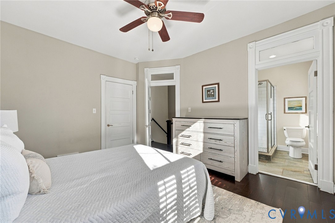 Interior space featuring dark wood-finish flooring, high ceilings with a central ceiling fan, and classic door frames with integrated transoms