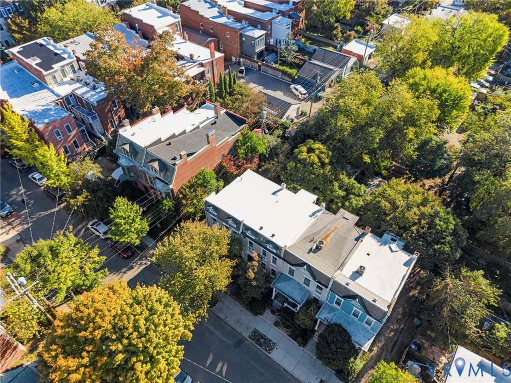 Aerial perspective of urban masonry architecture featuring flat roof structures and mature tree canopy throughout the immediate environment