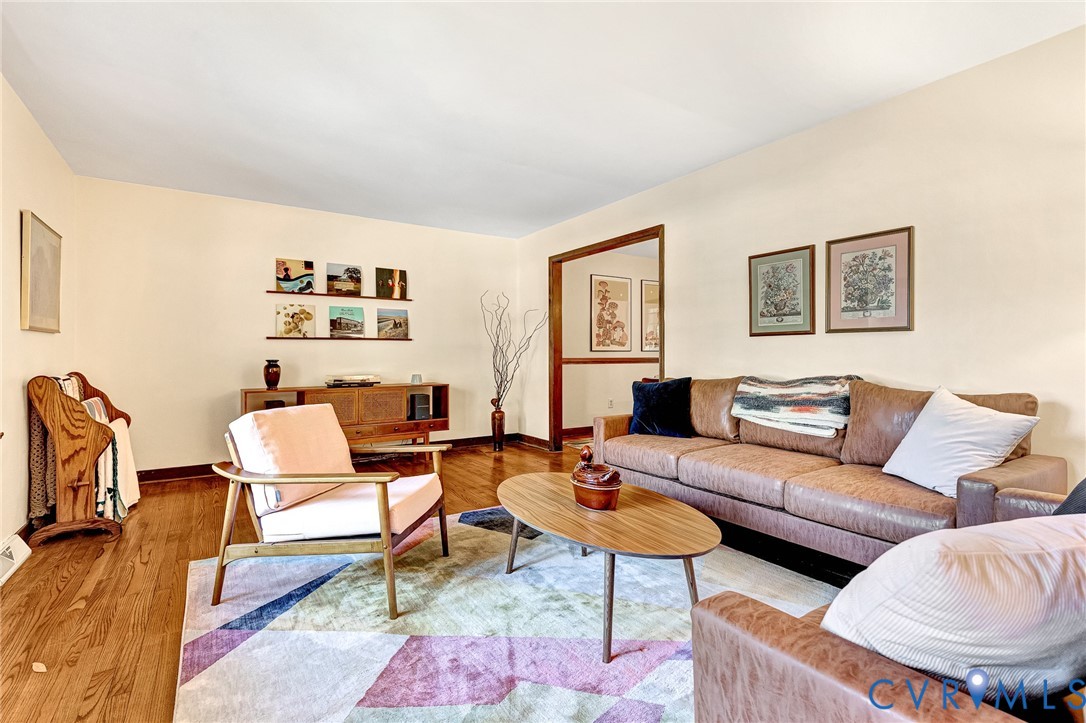 Living space featuring wood-finish flooring and a wide doorway with natural wood trim
