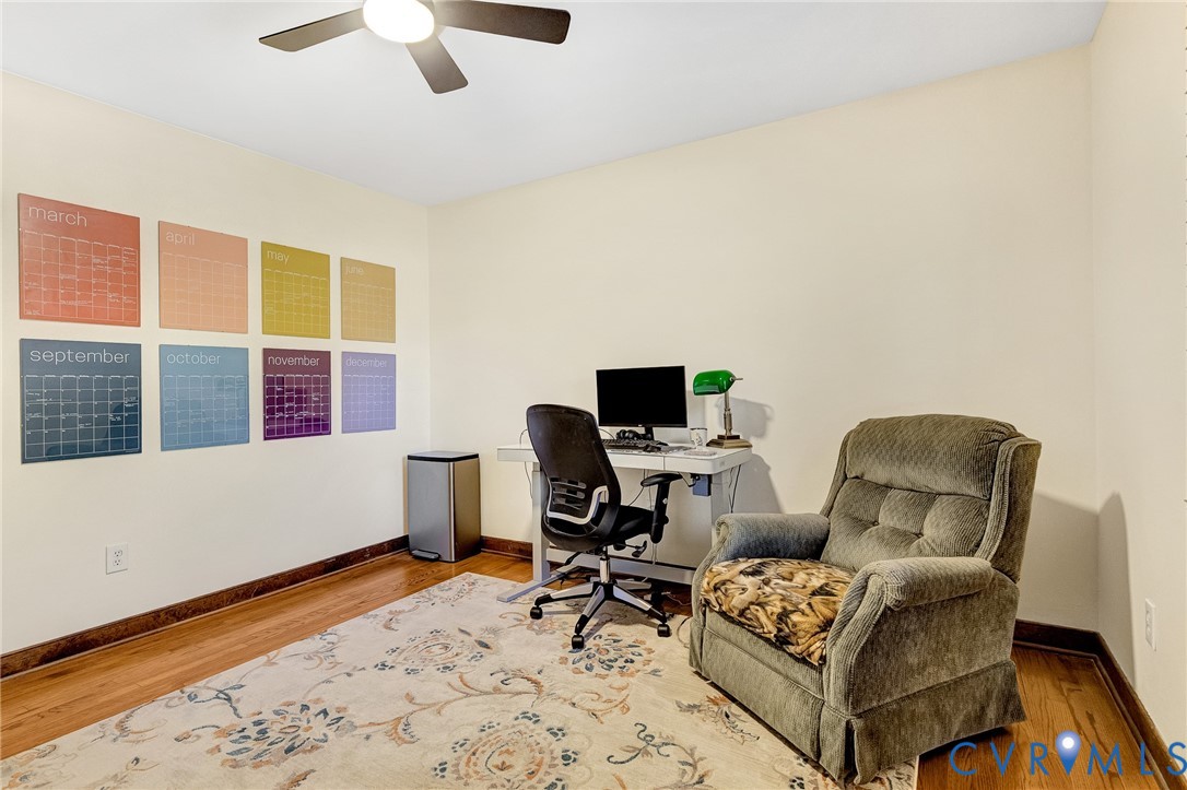 Wood-finish flooring and a central ceiling fan with an integrated light fixture