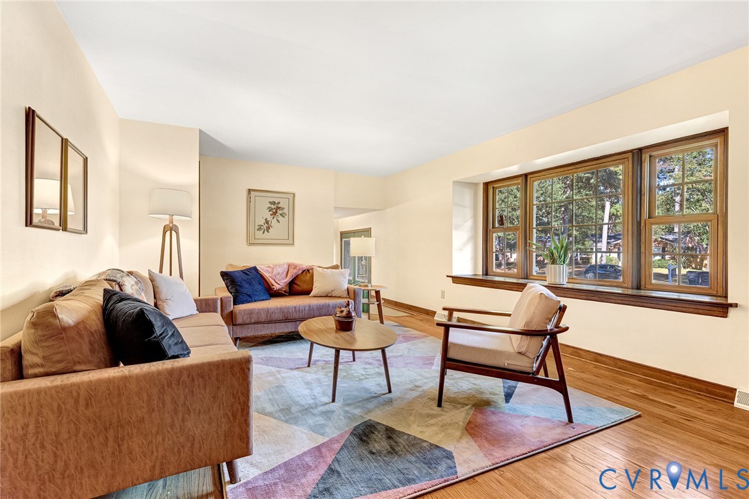 Living area featuring wood-finish flooring, a multi-pane bay window, and a wide window sill
