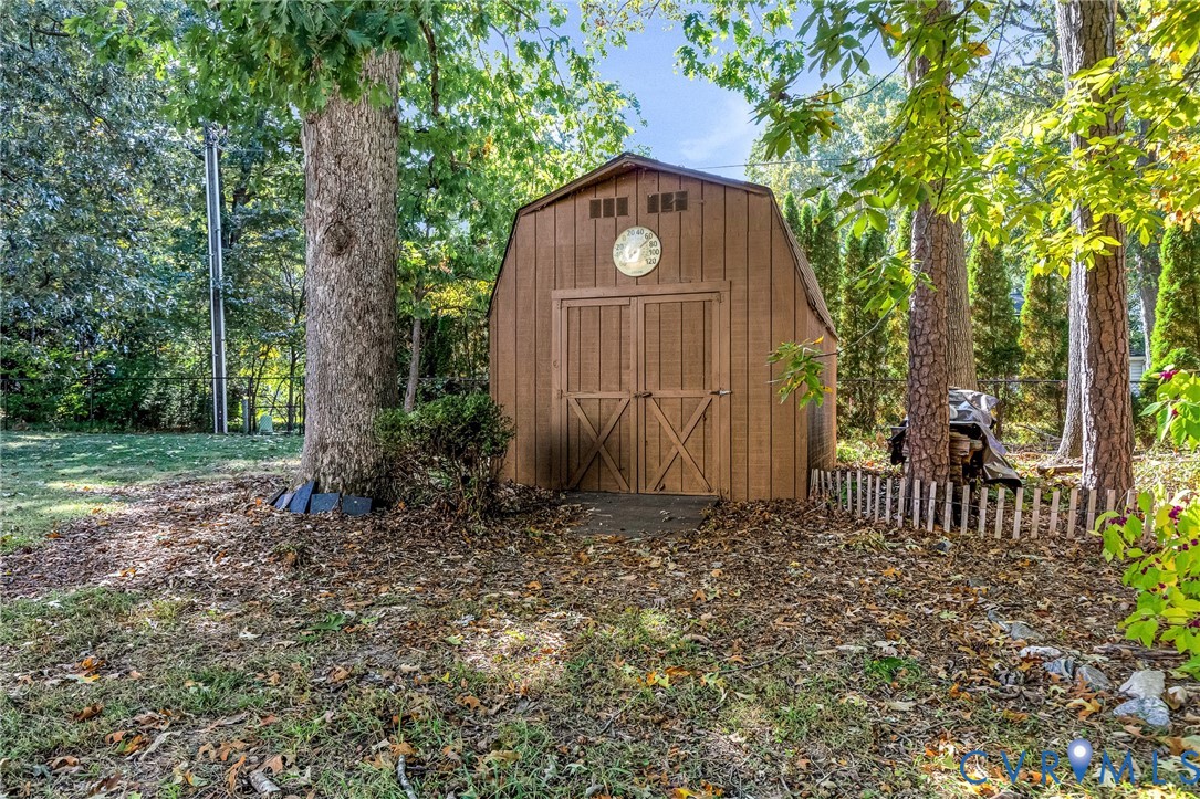 Storage structure featuring a gambrel roof design, double-door entry, and wood-finish siding