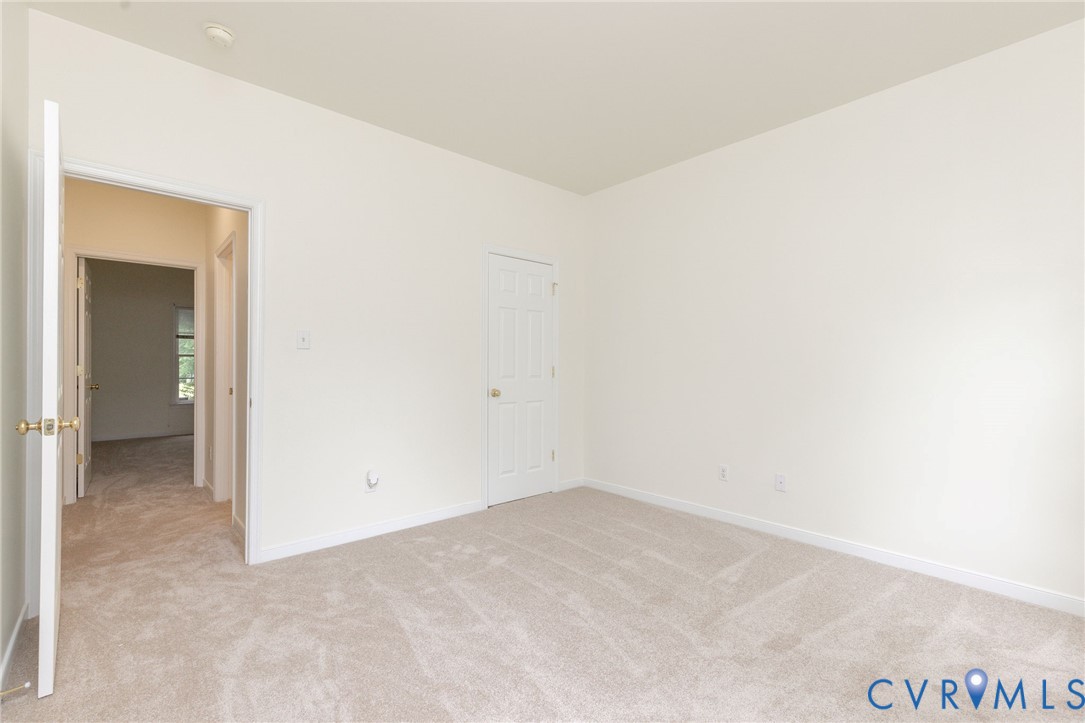 Neutral interior featuring wall-to-wall carpeting and a six-panel interior door