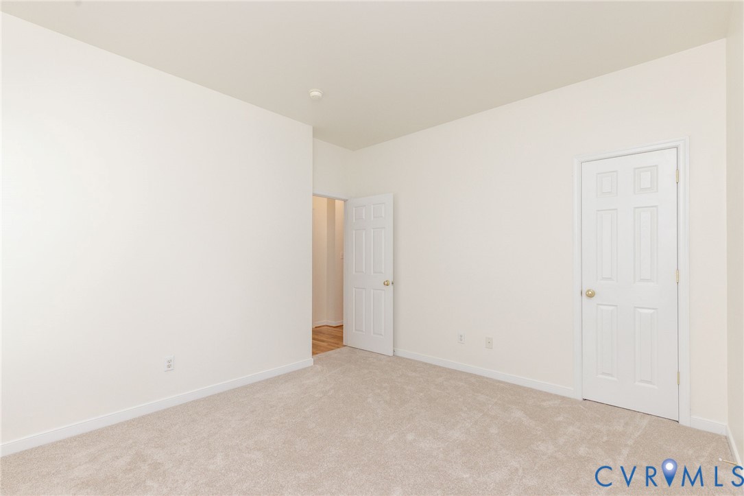 Neutral-toned wall paint, plush carpeting, and white six-panel doors