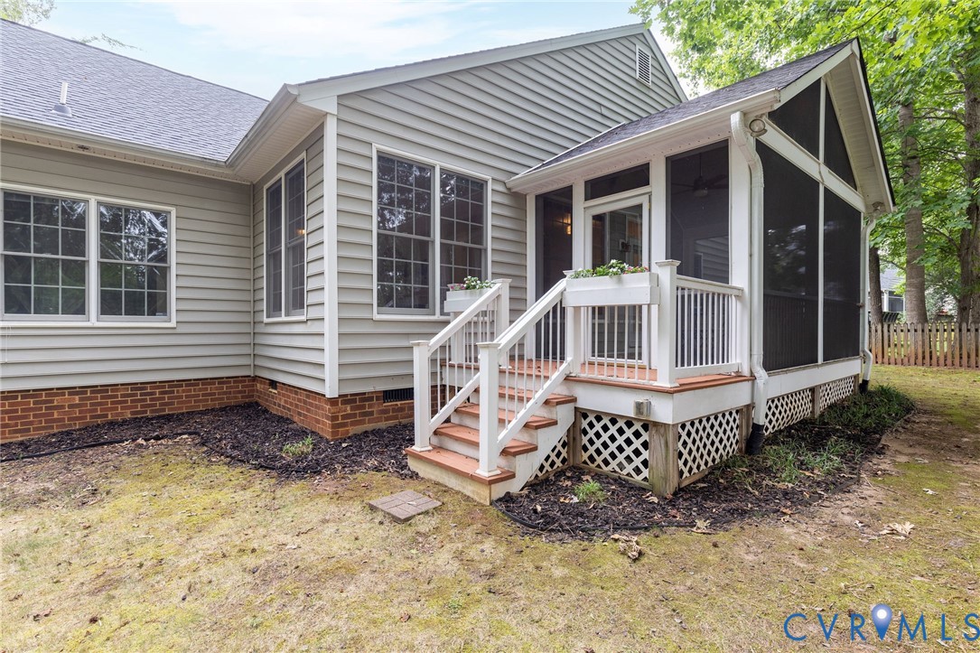 Exterior featuring horizontal lap siding, brick foundation masonry, and a screened porch with white railing, lattice skirting, and an integrated staircase