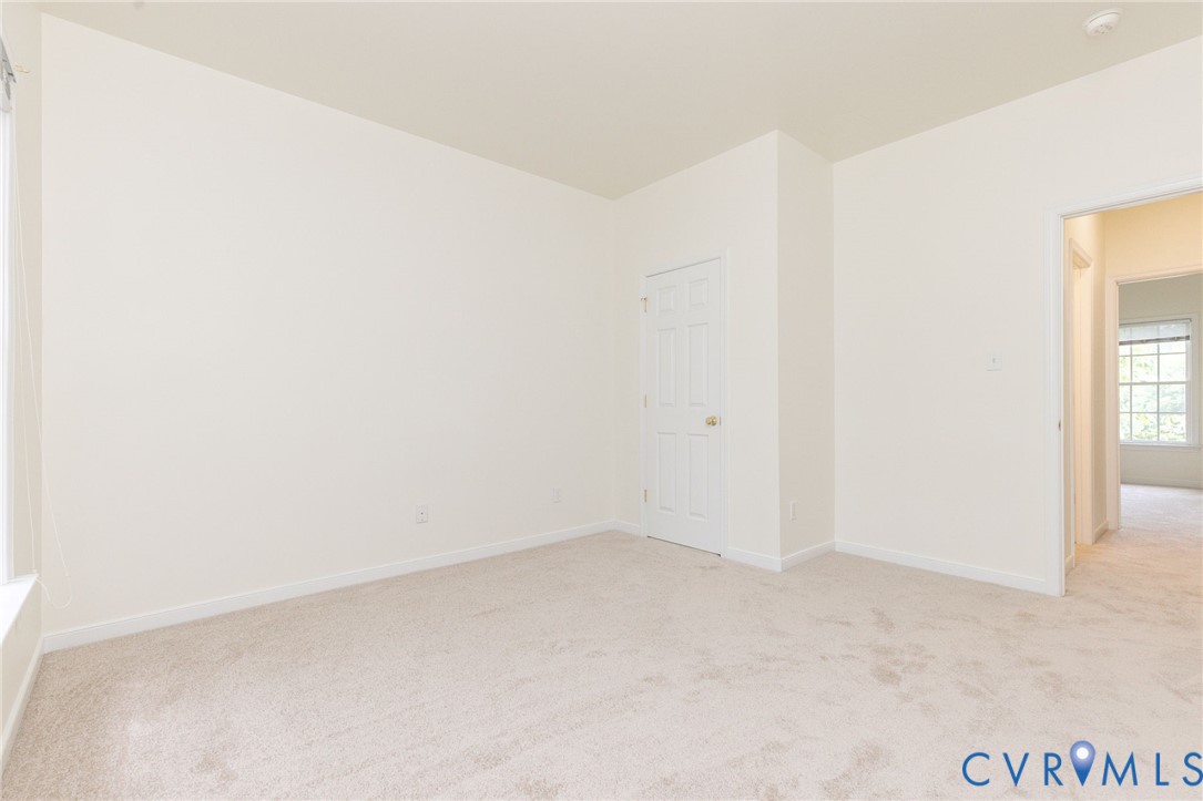 Neutral interior featuring high-pile wall-to-wall carpeting and a six-panel interior door