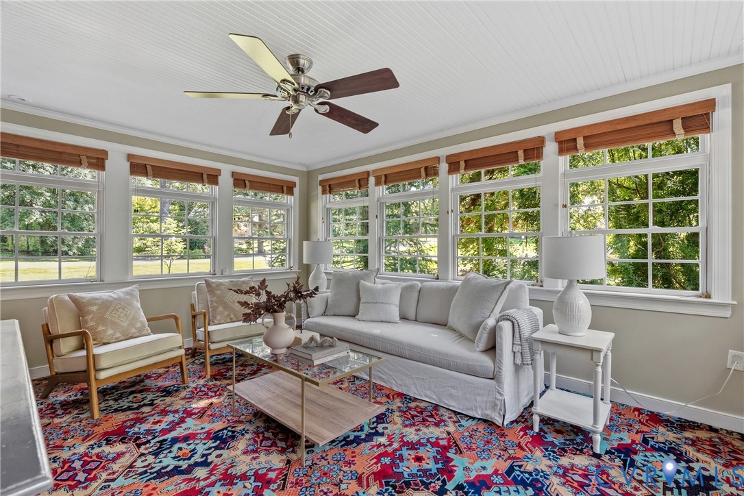 Sunroom featuring beadboard ceiling, multi-pane windows, and a central ceiling fan