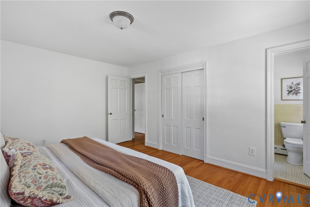 Wood-finish flooring, double-panel closet doors, and a ceiling-mounted flush-mount light fixture