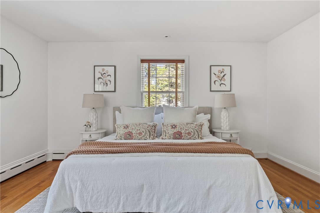 Neutral interior walls, wood-finish flooring, and single-pane window with wood-trim surround