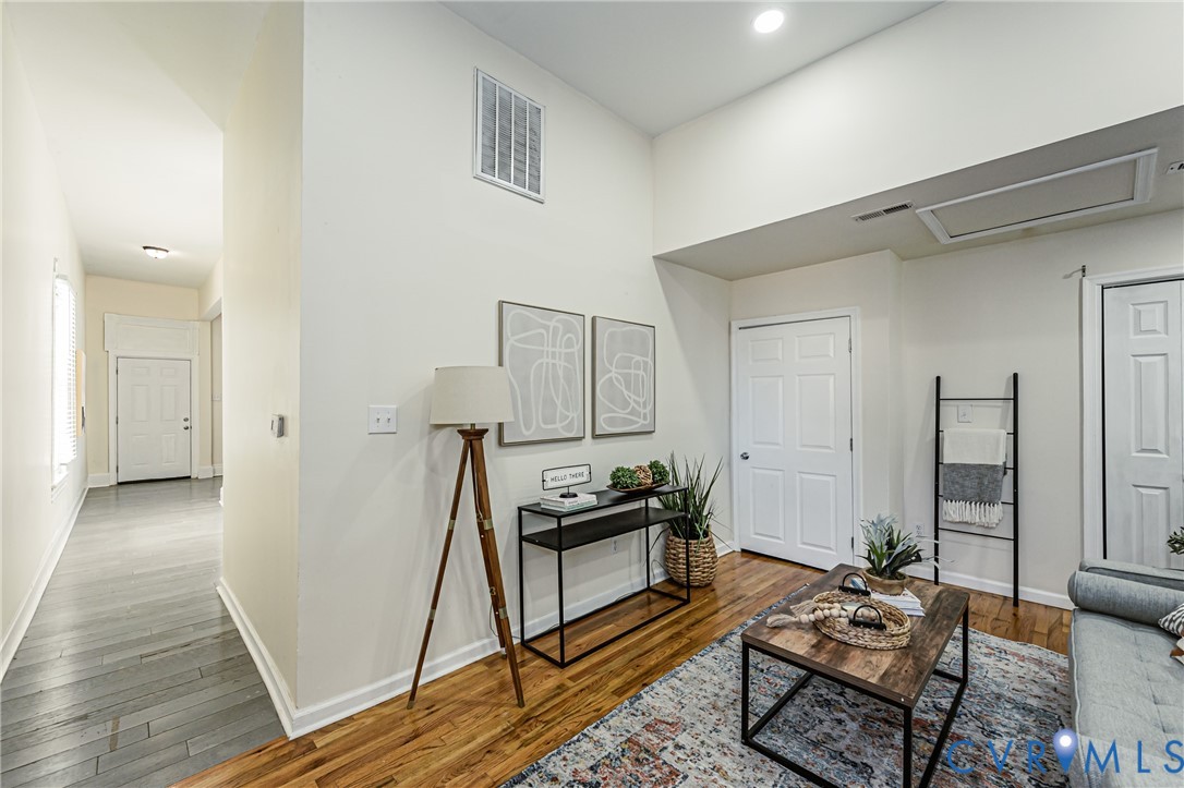 High-ceiling interior featuring wood-finish flooring, recessed lighting, and multi-panel interior doors