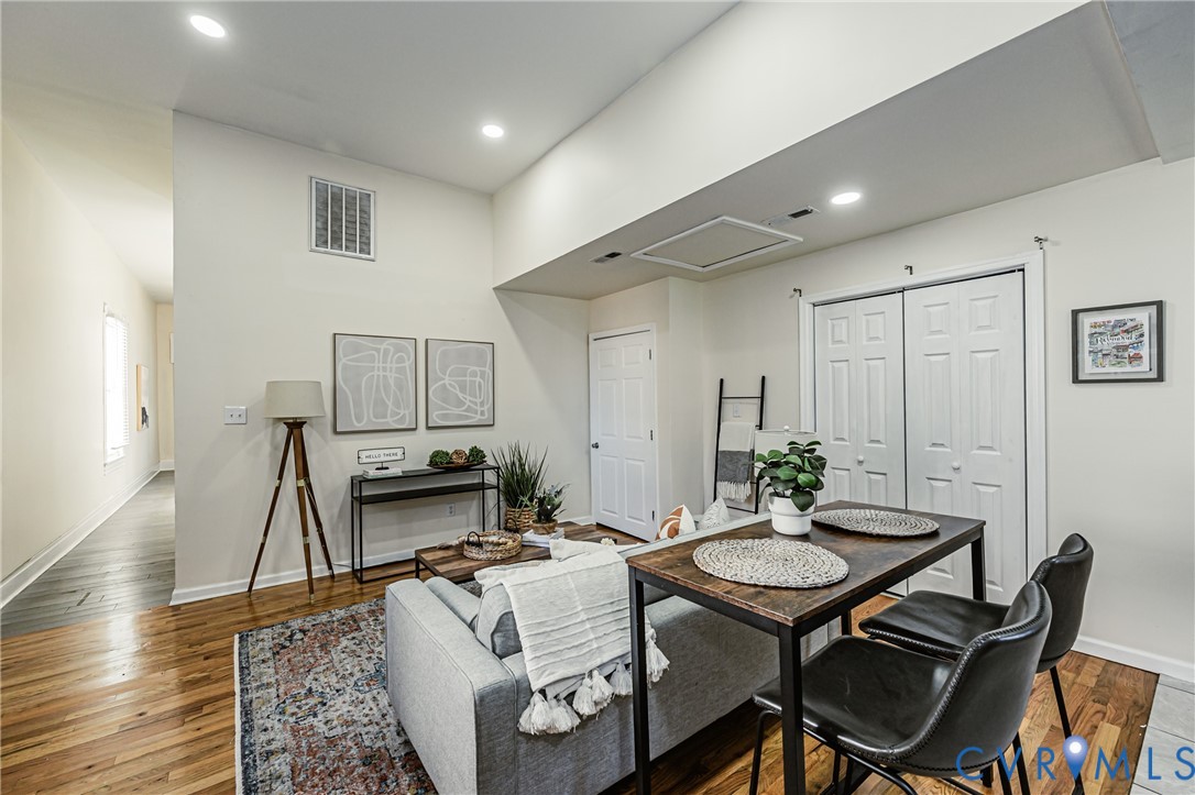 Open-concept interior featuring wood-finish flooring, recessed lighting, and double-door closet cabinetry
