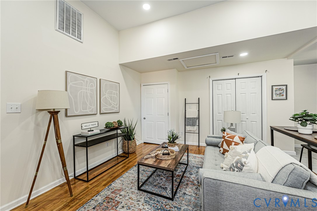 Vaulted ceiling featuring recessed lighting, wood-finish flooring, and double-door closet storage