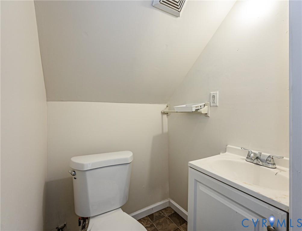 White vanity cabinet with an integrated sink, dual-handle chrome faucet, and white porcelain toilet