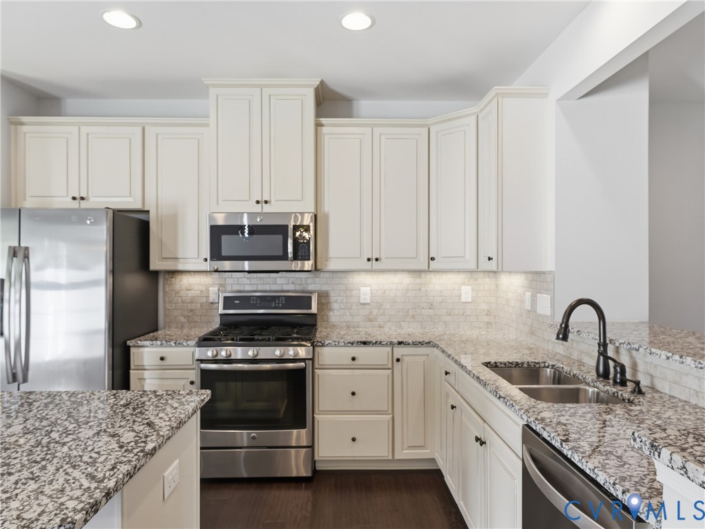 This modern kitchen is a chef's dream with a gas range, double sink, newer dishwasher (2024) and ample counterspace and storage space, including a pantry.