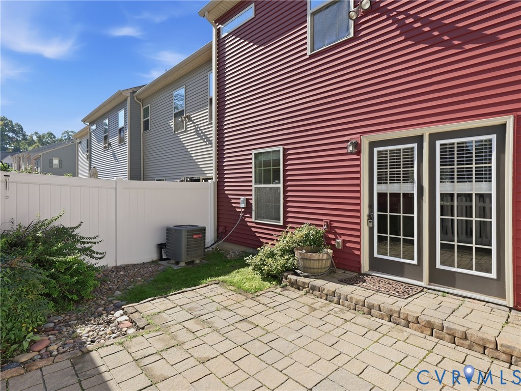 Brick rear patio and fully fenced backyard provide space for outdoor dining, relaxing, and entertaining