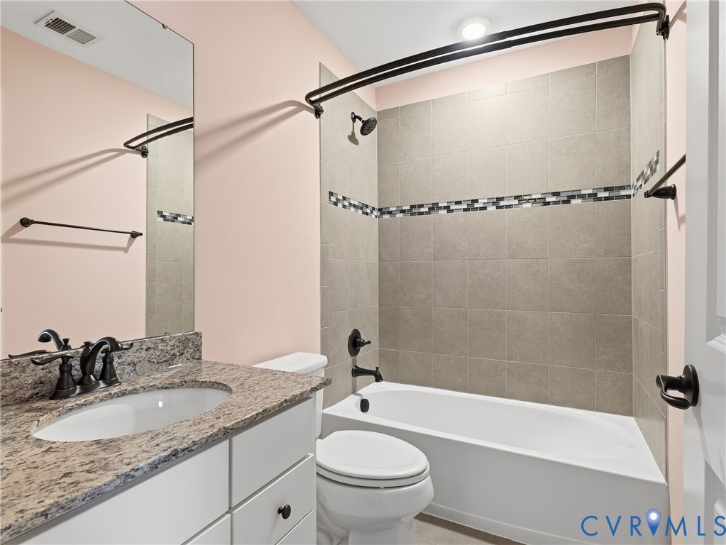 Full hallway bathroom with tiled shower/tub combo