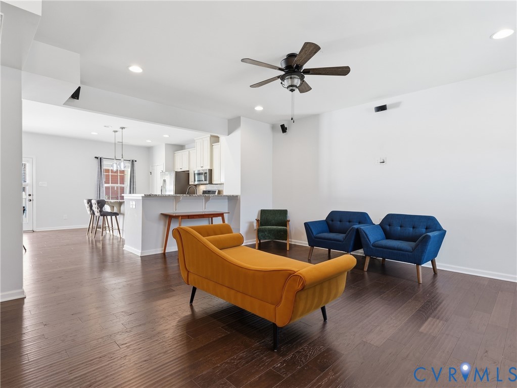 Open-concept living room with hardwood floors, recessed lighting, and a seamless connection to the kitchen.