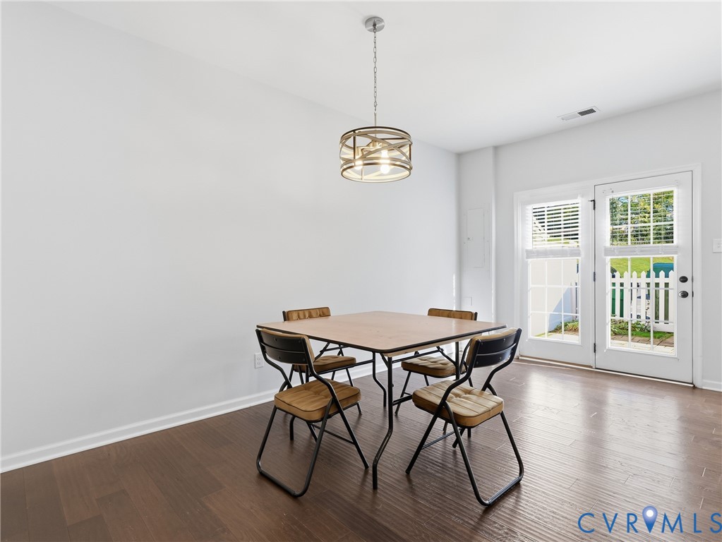 Sunlit dining area with hardwood flooring and direct access to the rear patio for indoor-outdoor dining and entertaining.