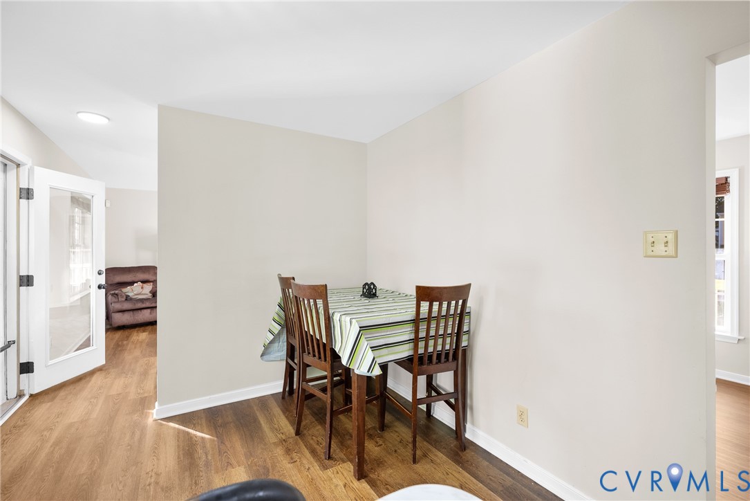 Neutral-toned interior walls featuring wood-finish flooring and a glass-paneled entry door Neutral-toned interior walls featuring wood-finish flooring and a glass-paneled entry door