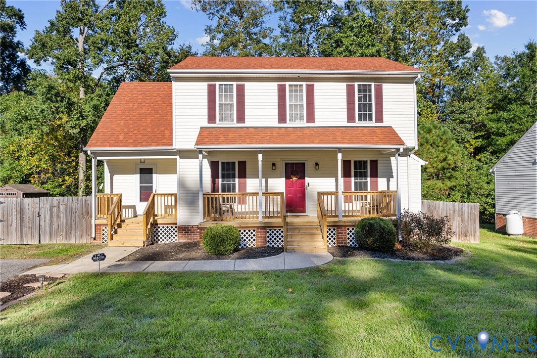 Two-story home with light-colored siding, contrasting shutters, a front porch with wood railings, lattice skirting, and a concrete walkway