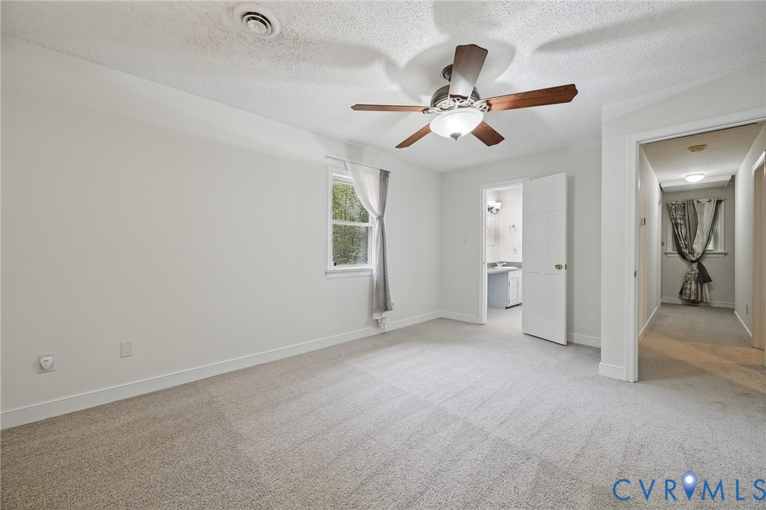 Neutral interior space featuring wall-to-wall carpeting, a ceiling fan with integrated lighting, and a single-hung window