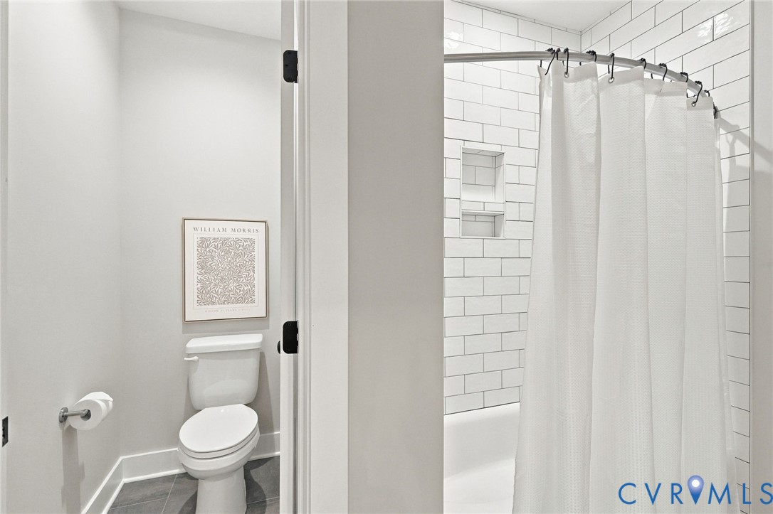 Something You Never See in a Hall Bathroom - a Water Closet.  The Tub/Shower has a Ceramic Surround.