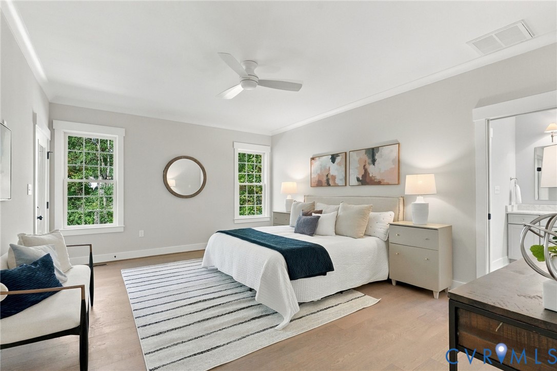 Primary Bedroom Features Hardwood Floors & Large Windows & a Marble Ensuite