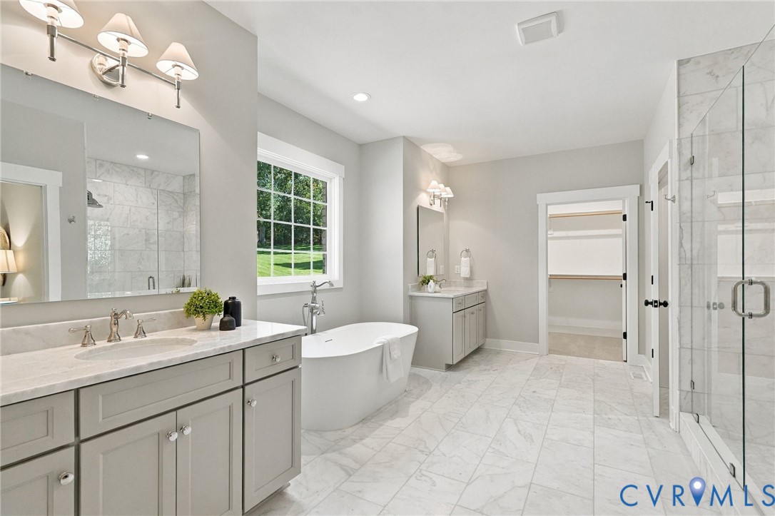 Stunning is the Only Way to Describe the Primary Bathroom--Carrera Marble Floors, 2 Large Vanities w/Marble Tops, Large Walk-In Carrera Marble Shower & Soaking Tub