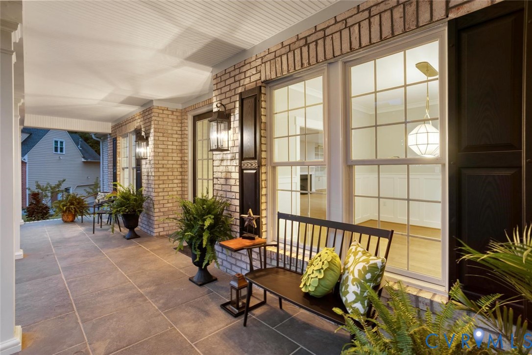 Brick exterior with a covered porch featuring large format tile flooring