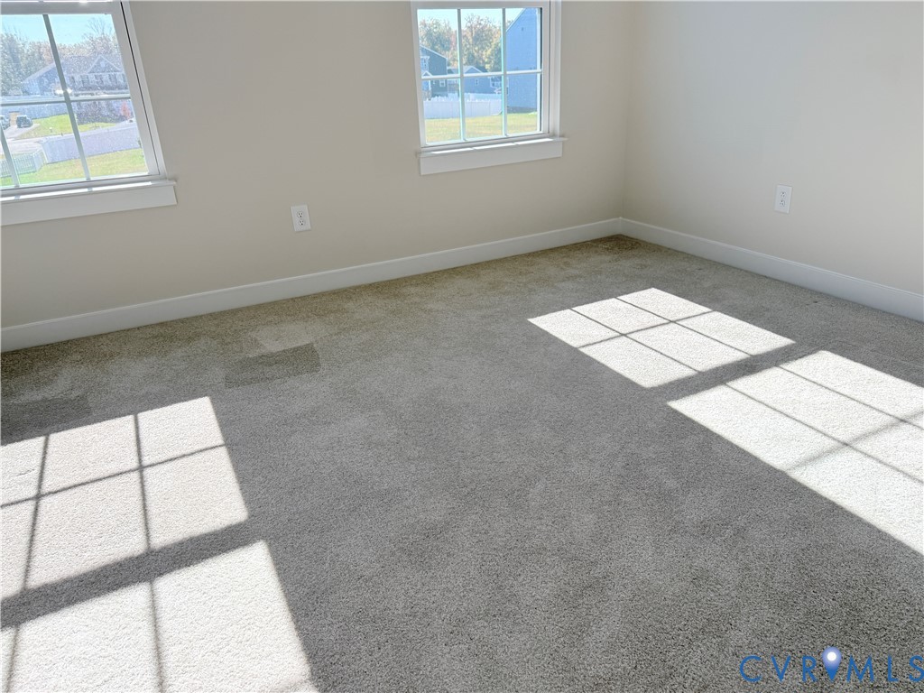 Neutral-toned carpeting, two double-hung windows with mullions, and crisp wall finishes